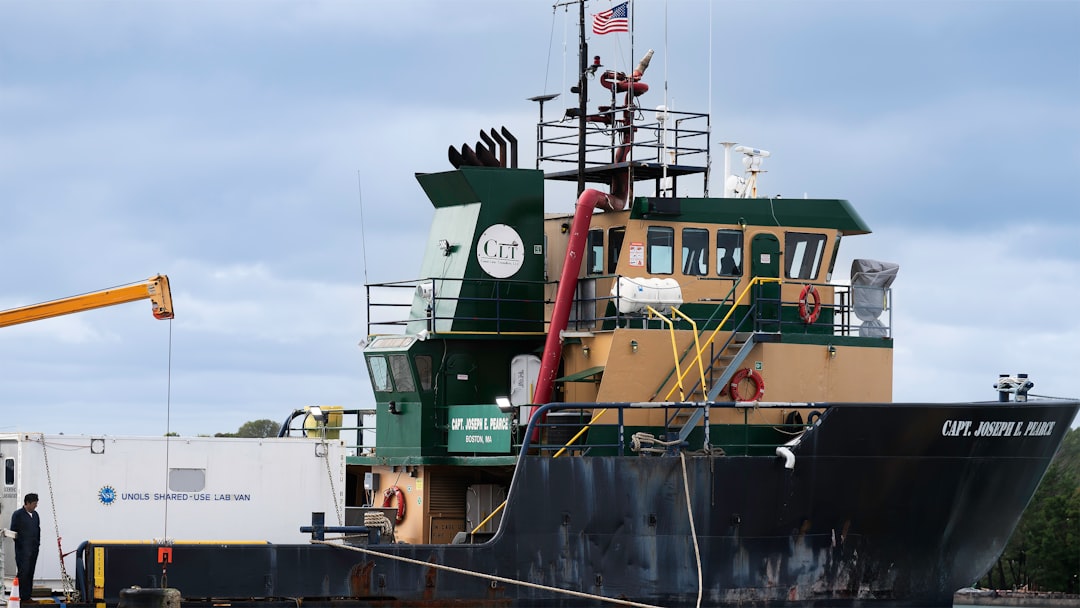 This image captures the Capt. Joseph E. Pierce, a working vessel docked at Woods Hole, Massachusetts, likely engaged in marine research. The UNOLS Shared-Use Lab Van suggests its tied to the University-National Oceanographic Laboratory System, supporting oceanographic studies. The ship, registered in Boston, MA, carries the logo of Cross Sound Ferry Services, hinting at its diverse roles in both ferry and research operations. With its sturdy structure and specialized equipment, the vessel supports scientific tasks such as deploying submersibles or gathering ocean data.
