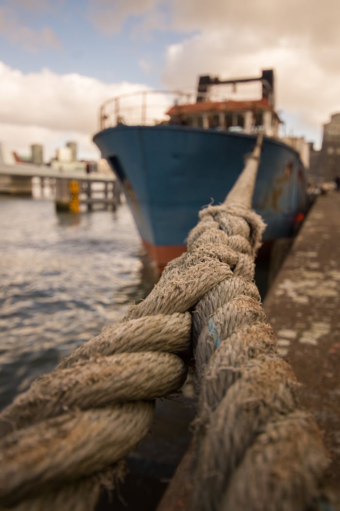 Detailed view of a thick nautical rope securing a ship at a harbor.