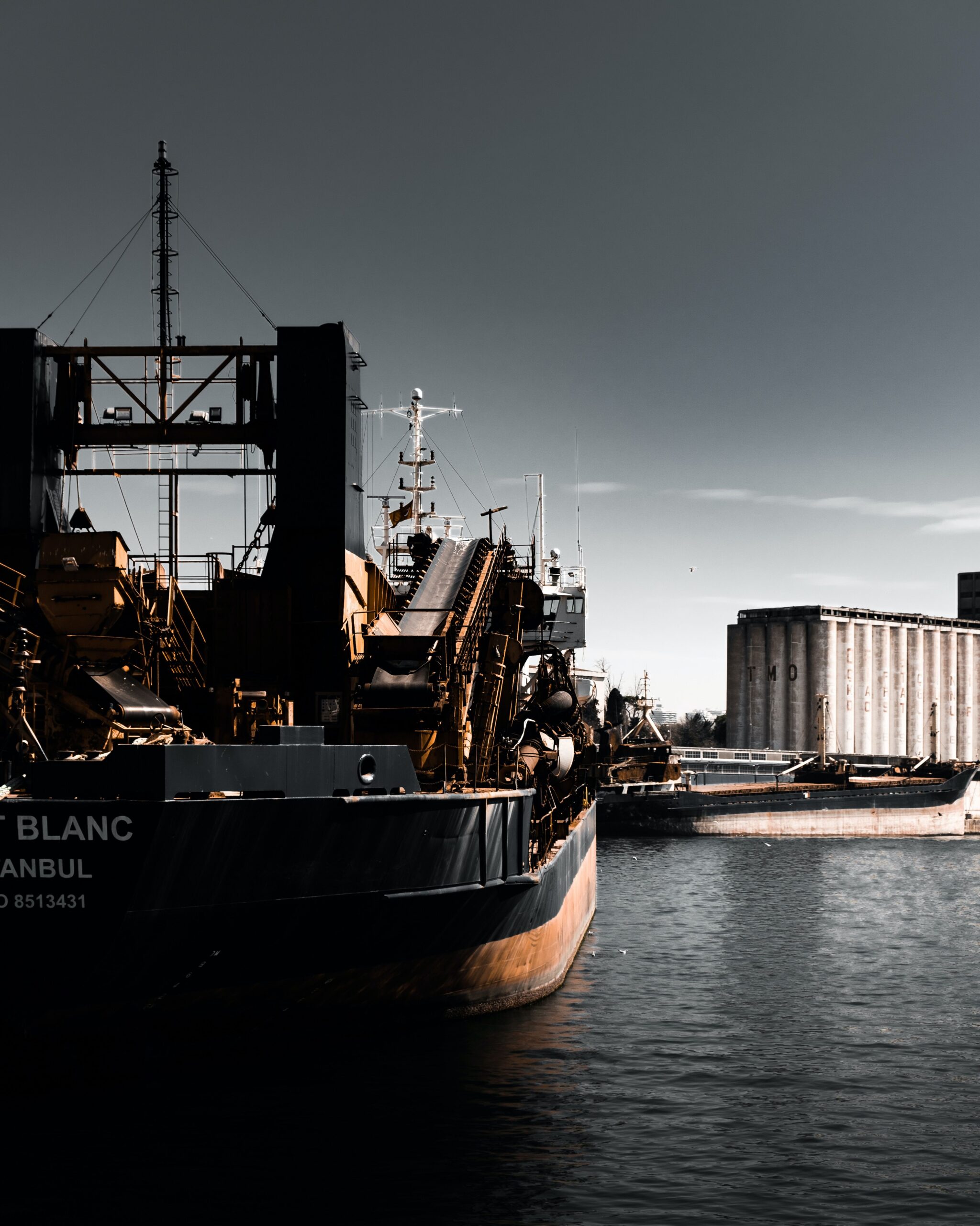 Moody view of a cargo ship moored in Istanbul harbor under a dusky sky.